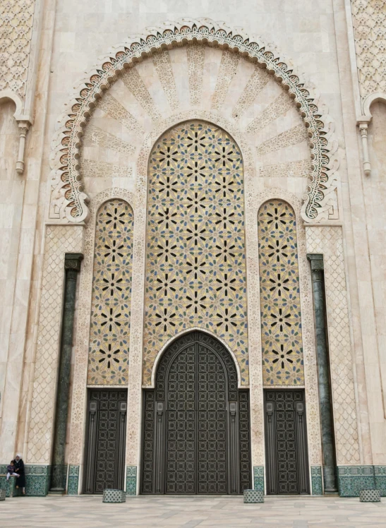 a person sitting on a bench in front of a building, a digital rendering, inspired by Alberto Morrocco, unsplash contest winner, arabesque, symmetrical doorway, moroccan mosque, 2 5 6 x 2 5 6 pixels, gold and steel intricate