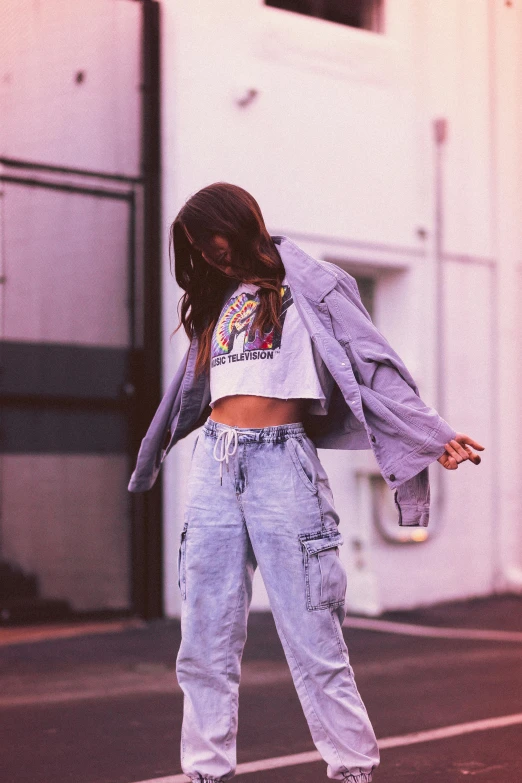 a woman standing on a skateboard on a city street, an album cover, inspired by Elsa Bleda, trending on pexels, graffiti, wearing cargo pants, beautiful midriff, white neon wash, profile image