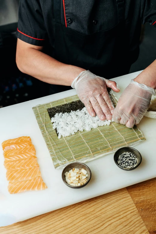 a person making sushi on a cutting board, at the counter, medium, extra details, fully covered