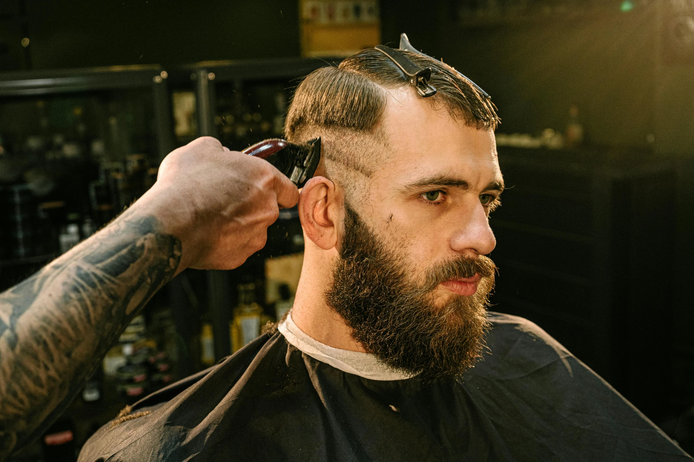 a man getting his hair cut at a barber shop, an album cover, trending on pexels, curled beard, ned kelly, style of seb mckinnon, press shot