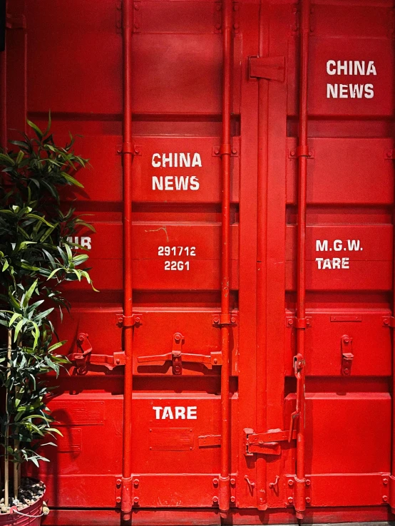 a red shipping container sitting next to a potted plant, by Weiwei, temporary art, news report, copyright time magazine, china town, chinese text