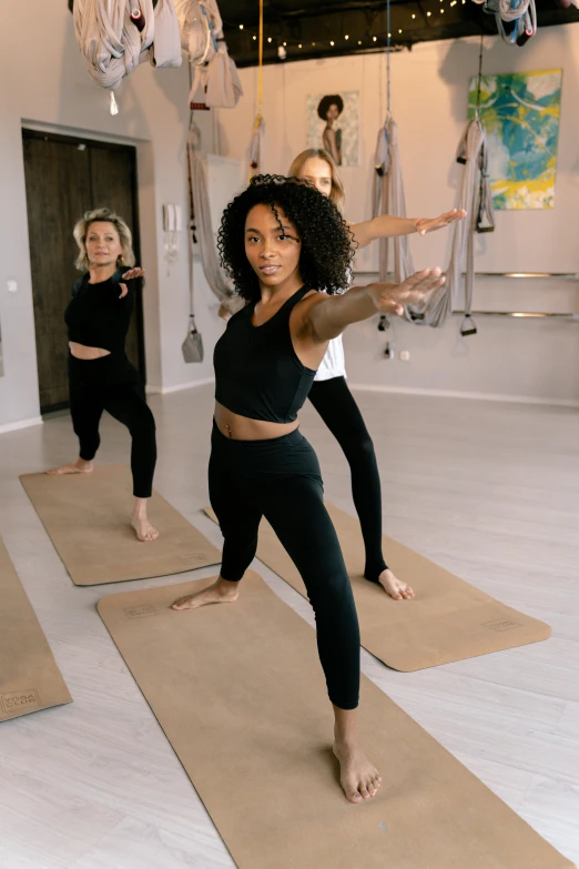 a group of women doing yoga in a room, by Carey Morris, trending on pexels, arabesque, standing athletic pose, thumbnail, low quality photo, 2717433015