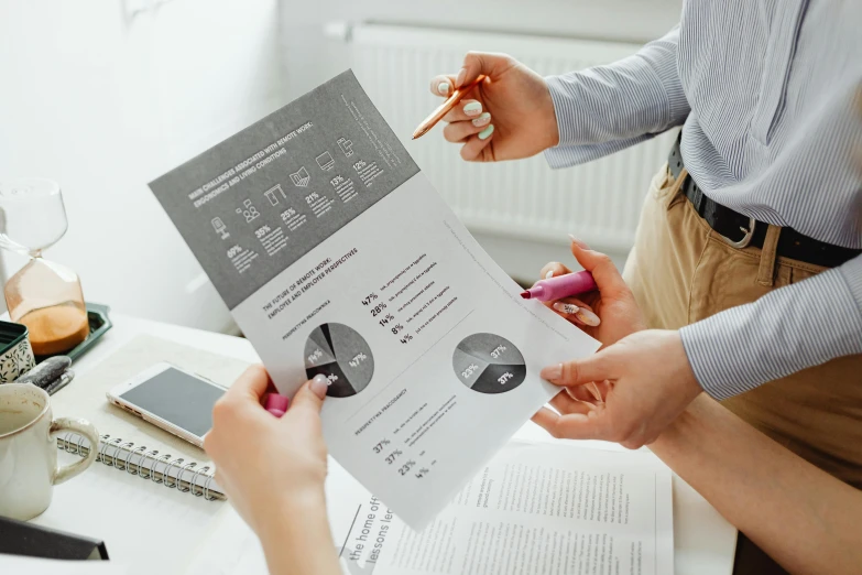 a couple of people that are sitting at a table, trending on unsplash, private press, informative graphs and diagrams, holding pencil, on grey background, brochure