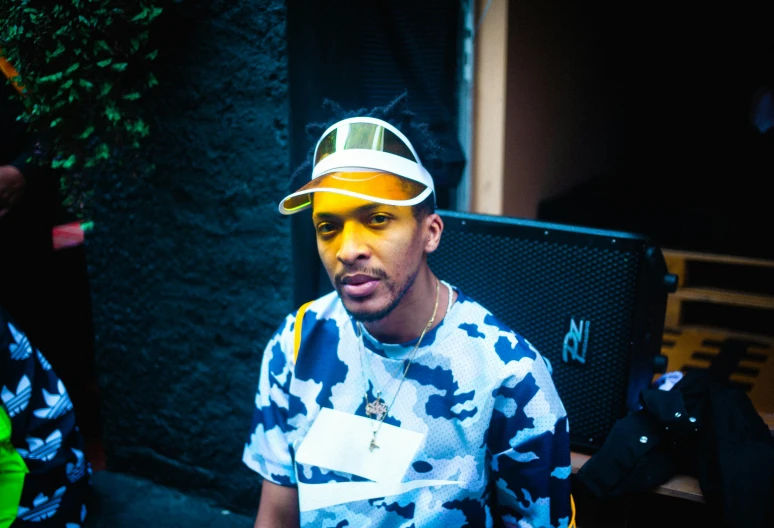 a man with yellow paint on his face, an album cover, unsplash, graffiti, wearing a bandana and chain, he is wearing a hat, frank ocean, family photo