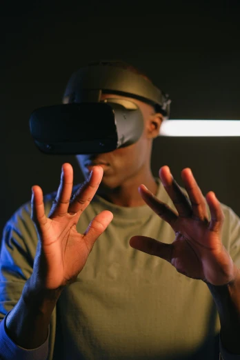 a man wearing a virtual reality headset in a dark room, a hologram, pexels, afrofuturism, enhanced hands, gesture, raytracing on, year 2099