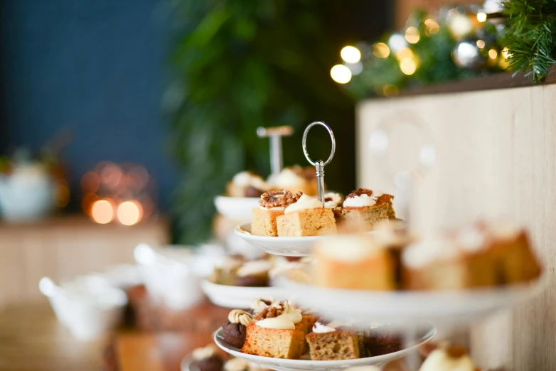 a number of plates of food on a table, a tilt shift photo, by Emma Andijewska, pexels, cake in hand, holiday season, square, tea