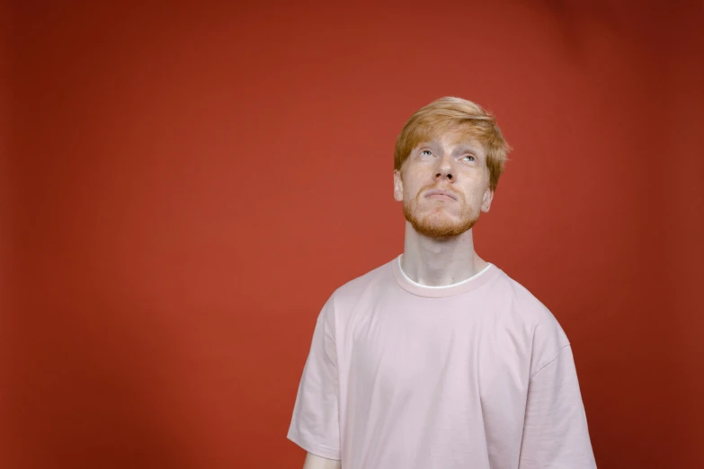 a man standing in front of a red wall, trending on pexels, hyperrealism, ginger hair, on a pale background, disappointed, 15081959 21121991 01012000 4k