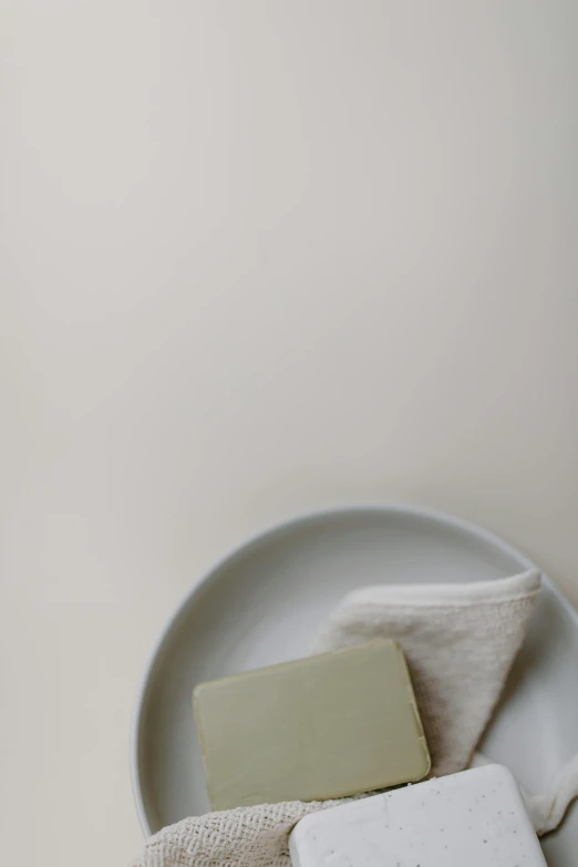 a white plate topped with different types of soap, unsplash, minimalism, muted green, ecru cloth, dwell, set photo
