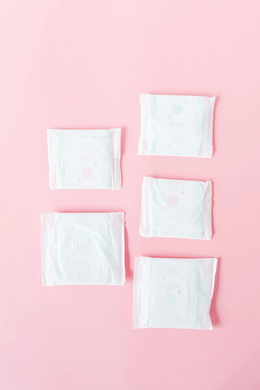 a bunch of tissues sitting on top of a pink surface, square shapes, product image, viewed from behind, small