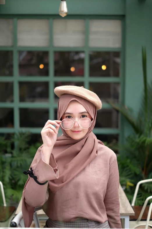 a woman wearing a hijab talking on a cell phone, inspired by Bernardino Mei, instagram, caracter with brown hat, ((portrait)), casual pose, shot with sony alpha