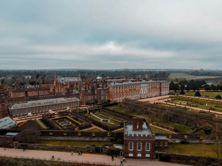 a large building sitting on top of a lush green field, by Joseph Severn, pexels contest winner, royal garden background, winter, looking down on the view, festivals