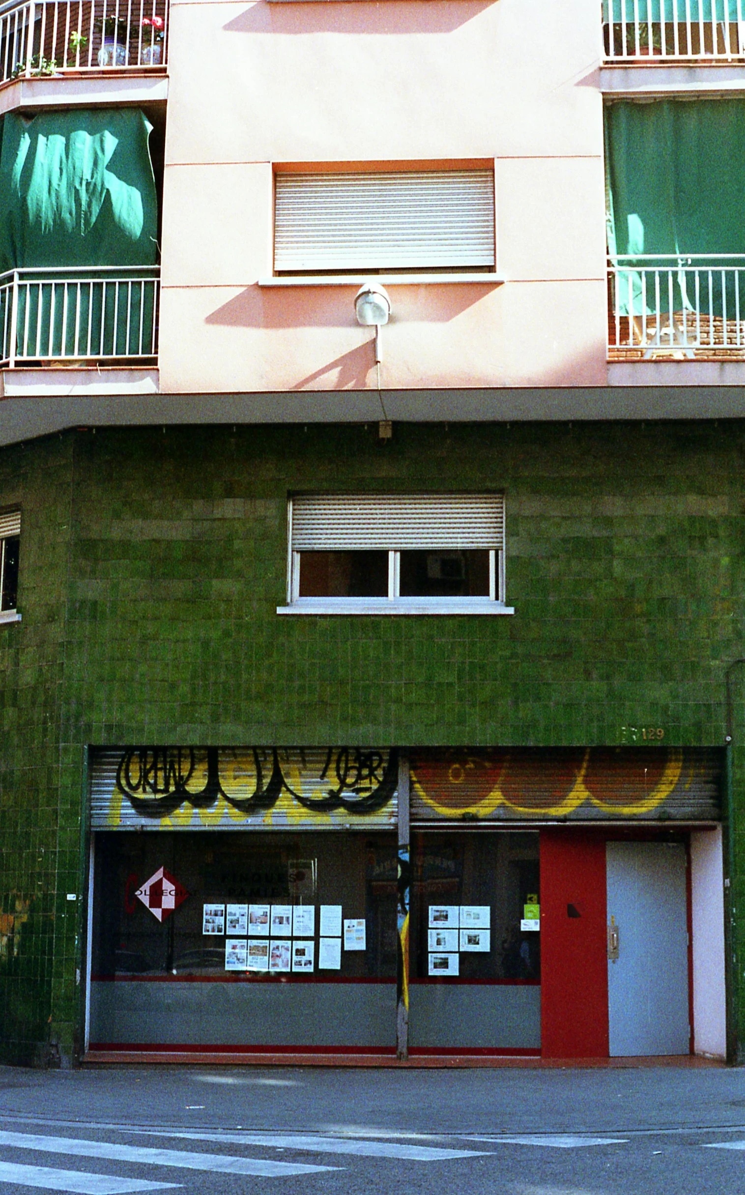 a red fire hydrant sitting in front of a green building, an album cover, by Pablo Rey, graffiti, panoramic view, shop front, low quality photo, tiled