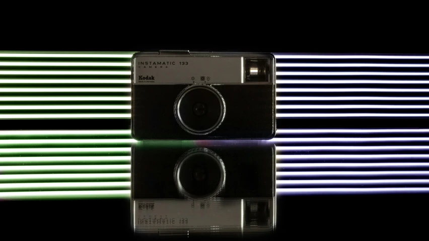 a camera sitting on top of a reflective surface, inspired by Richard Anuszkiewicz, flickr contest winner, holography, rainbow neon strips, taken on a 1960s kodak camera, symmetric lights, ramatic cinematic lighting