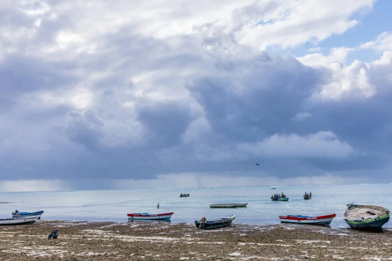 a group of boats sitting on top of a sandy beach, by Peter Churcher, pexels contest winner, stormy clouds on the horizon, in chuquicamata, panoramic, fishing