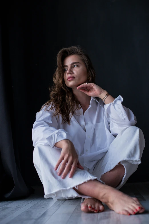 a woman sitting on the floor in a white shirt, a portrait, trending on unsplash, androgyny, dasha taran, promotional image, multiple stories