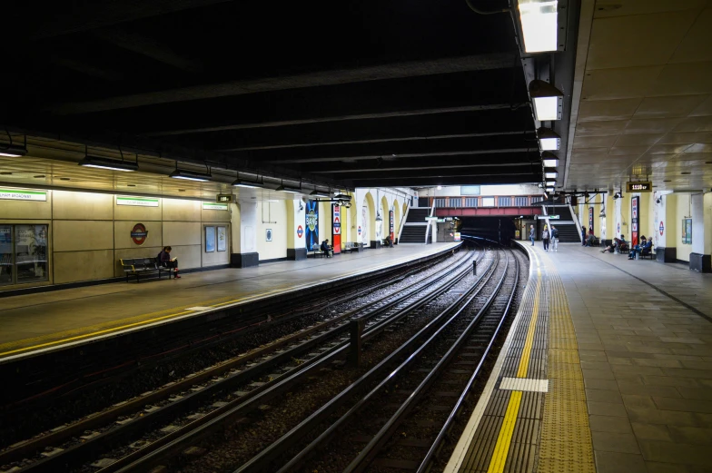a train pulling into a train station next to a platform, inspired by Thomas Struth, unsplash, london underground tube station, square, thumbnail, 8k octan photo