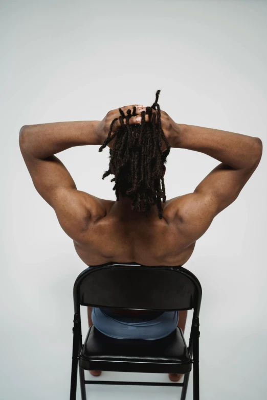 a man with dreadlocks sitting in a chair, pexels contest winner, black arts movement, rear side portrait of a muscular, bendover posture, set against a white background, short hair on top of his head