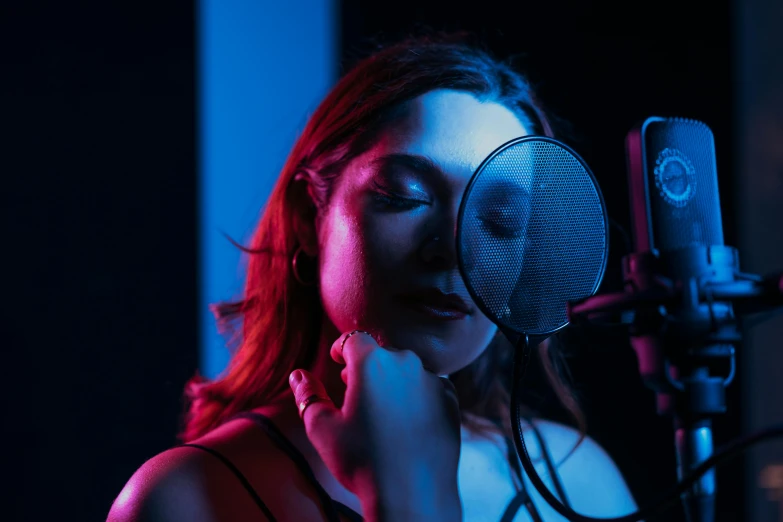 a woman singing into a microphone in a recording studio, an album cover, by Julia Pishtar, pexels, sasha grey, blue and red lighting, avatar image, sydney hanson