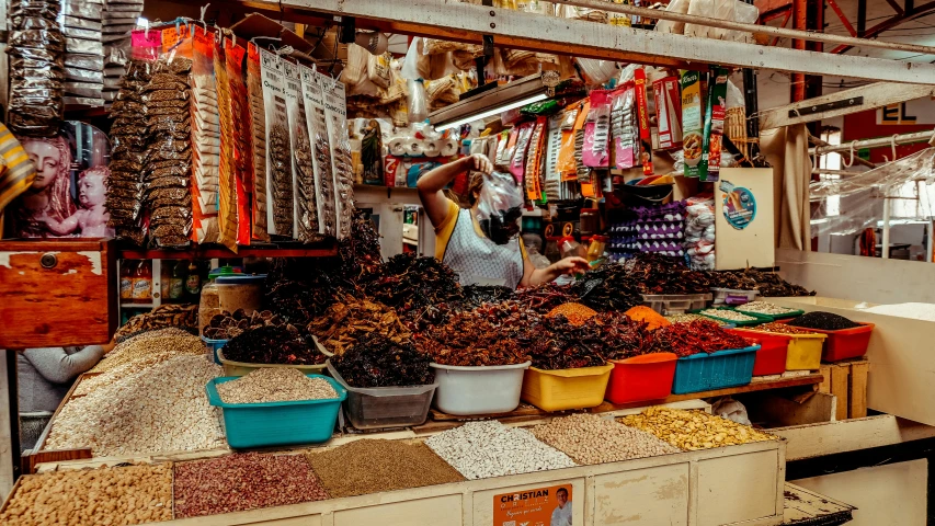 a store filled with lots of different types of food, by Julia Pishtar, pexels contest winner, downtown mexico, avatar image, somalia, a person standing in front of a