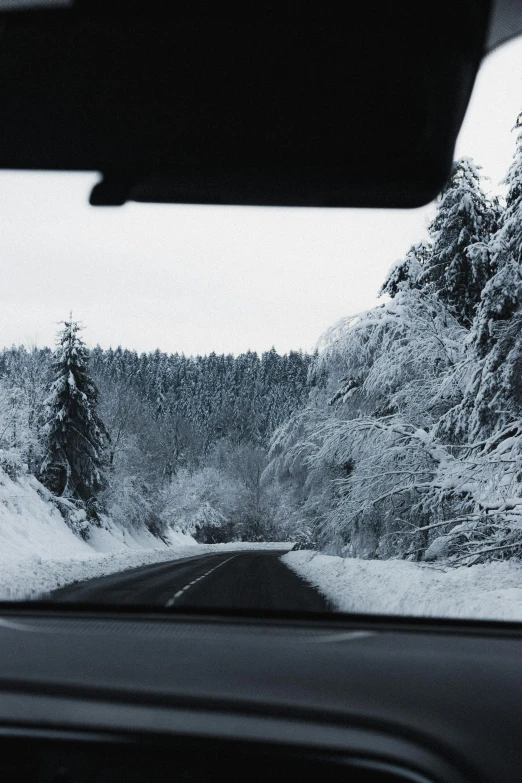 a car driving down a snow covered road, black forest, inside of a car, thumbnail, intricate environment - n 9