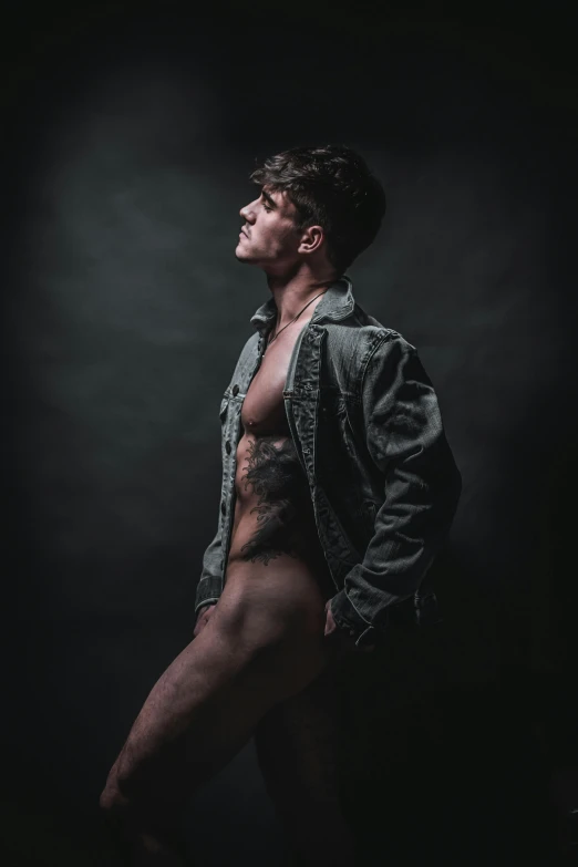 a shirtless man standing in front of a black background, an album cover, by Chase Stone, unsplash contest winner, non binary model, wearing dirty ripped flight suit, profile pic, indoor picture