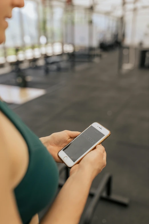 a woman holding a cell phone in a gym, by Adam Marczyński, trending on pexels, square, low detail, corporate phone app icon, programming