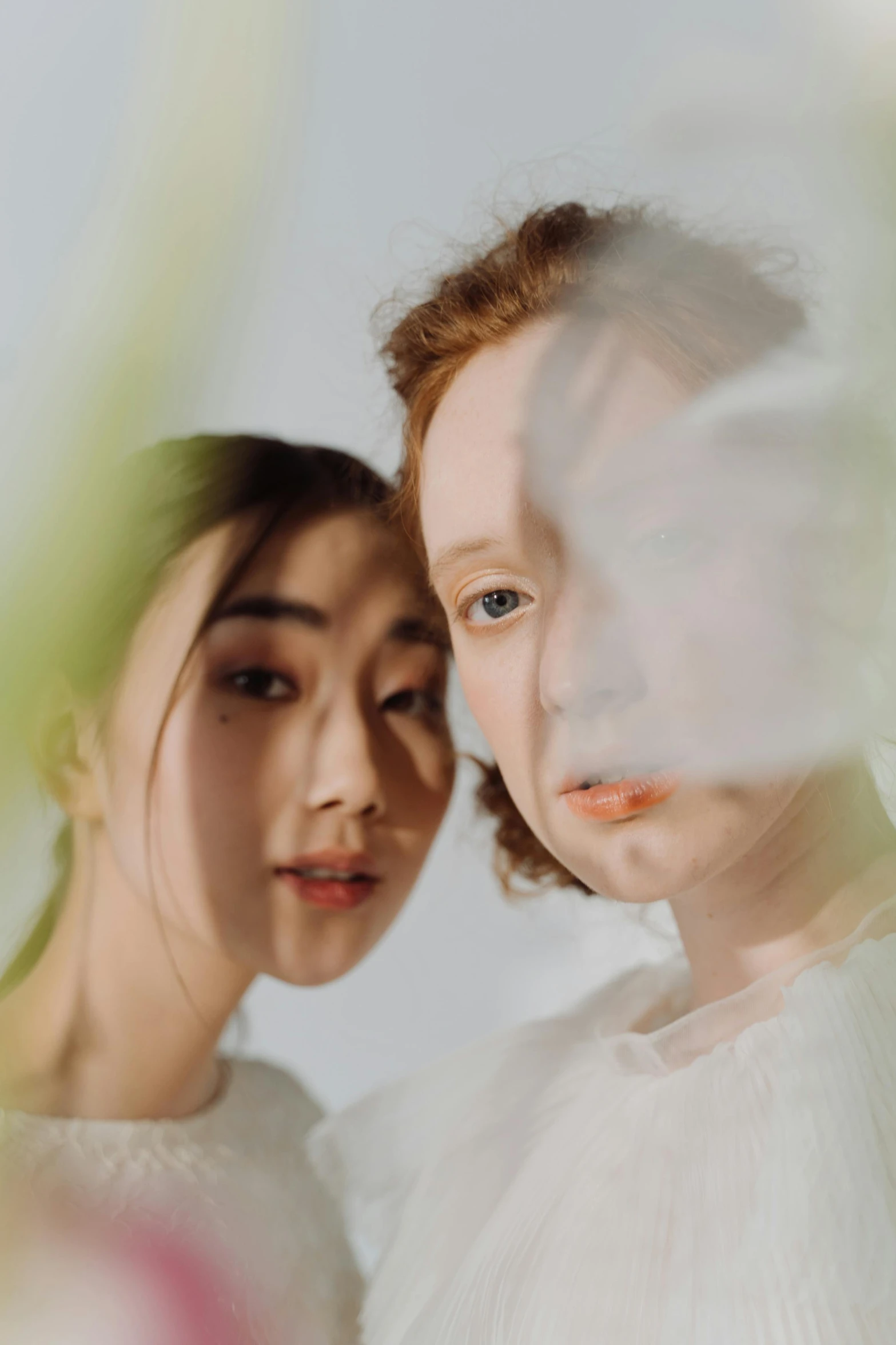 a couple of women standing next to each other, inspired by Wang Duo, trending on pexels, surrealism, pale round face, translucent sss, studio portrait, young asian girl