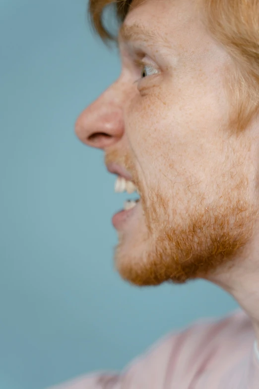 a man is brushing his teeth with a toothbrush, an album cover, by Lee Gatch, reddit, hyperrealism, ginger hair with freckles, close - up profile face, profile image, beard stubble