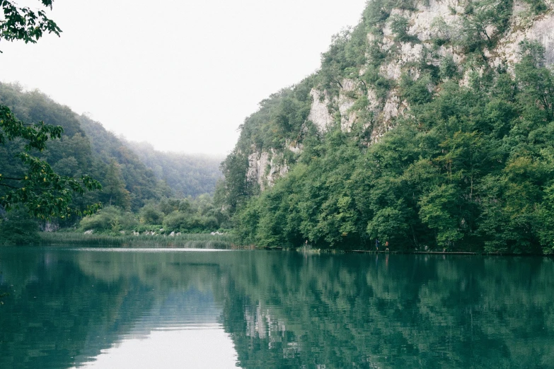 a large body of water surrounded by trees, by Emma Andijewska, pexels contest winner, hurufiyya, limestone, 2000s photo, natasha tan maciej kuciara, touring