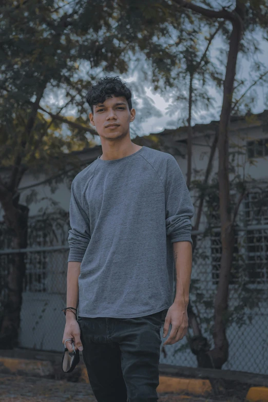 a young man standing on top of a skateboard, an album cover, inspired by John Luke, pexels contest winner, realism, dressed in a gray, profile image, long sleeves, asian male