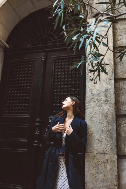 a woman standing in front of a black door, pexels contest winner, baroque, candid photo of gal gadot, in barcelona, ✨🕌🌙, nature outside