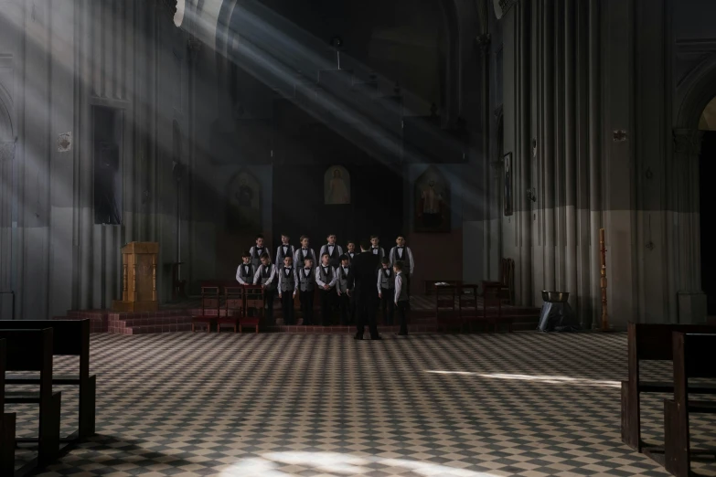 a group of men standing next to each other in a church, an album cover, by Raphaël Collin, unsplash contest winner, light and space, sunbeams, ignant, servants, anna nikonova