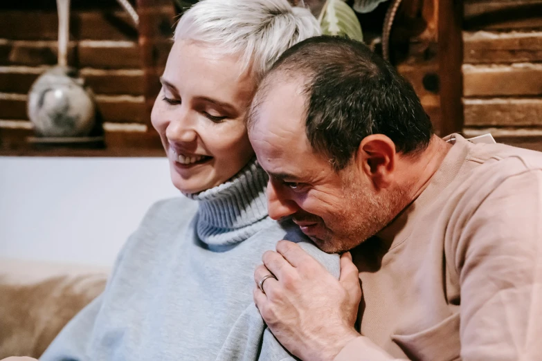 a man sitting next to a woman on a couch, pexels contest winner, short grey hair, two men hugging, profile image, warm and gentle smile