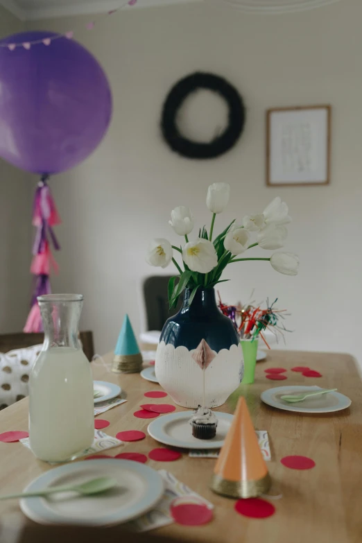 a table set for a birthday party with balloons and confetti, a still life, unsplash, white vase, unedited, tulip, purple accents