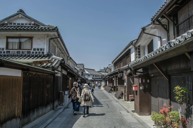 a group of people walking down a narrow street, shin hanga, ryokans and edo era houses, sunny day time, shops, 奈良美智