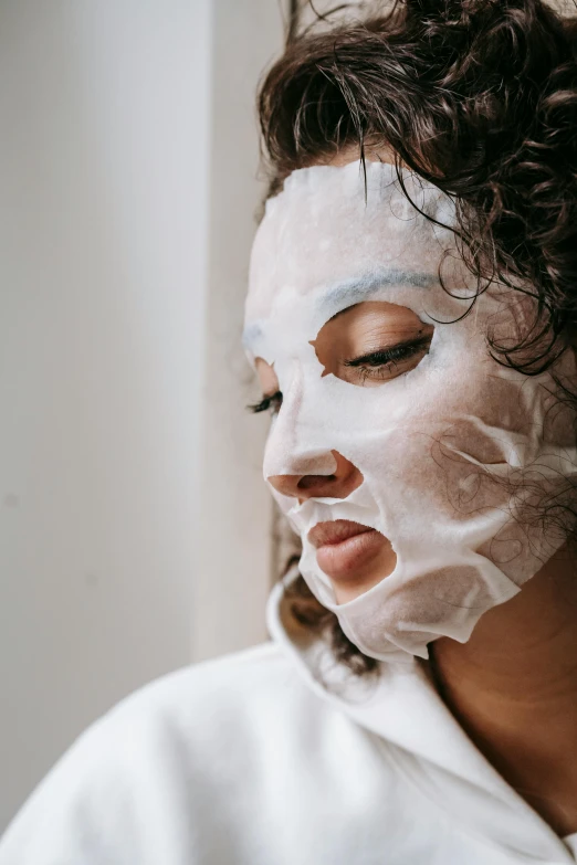 a woman with a sheet mask on her face, looking to the side off camera, mask off, detailed face )