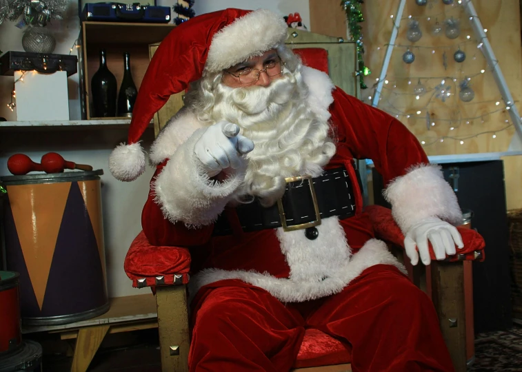 a man dressed as santa claus sitting in a chair, by Alice Mason, pexels, giving the middle finger, ”ultra realistic, drinking, ( ultra realistic