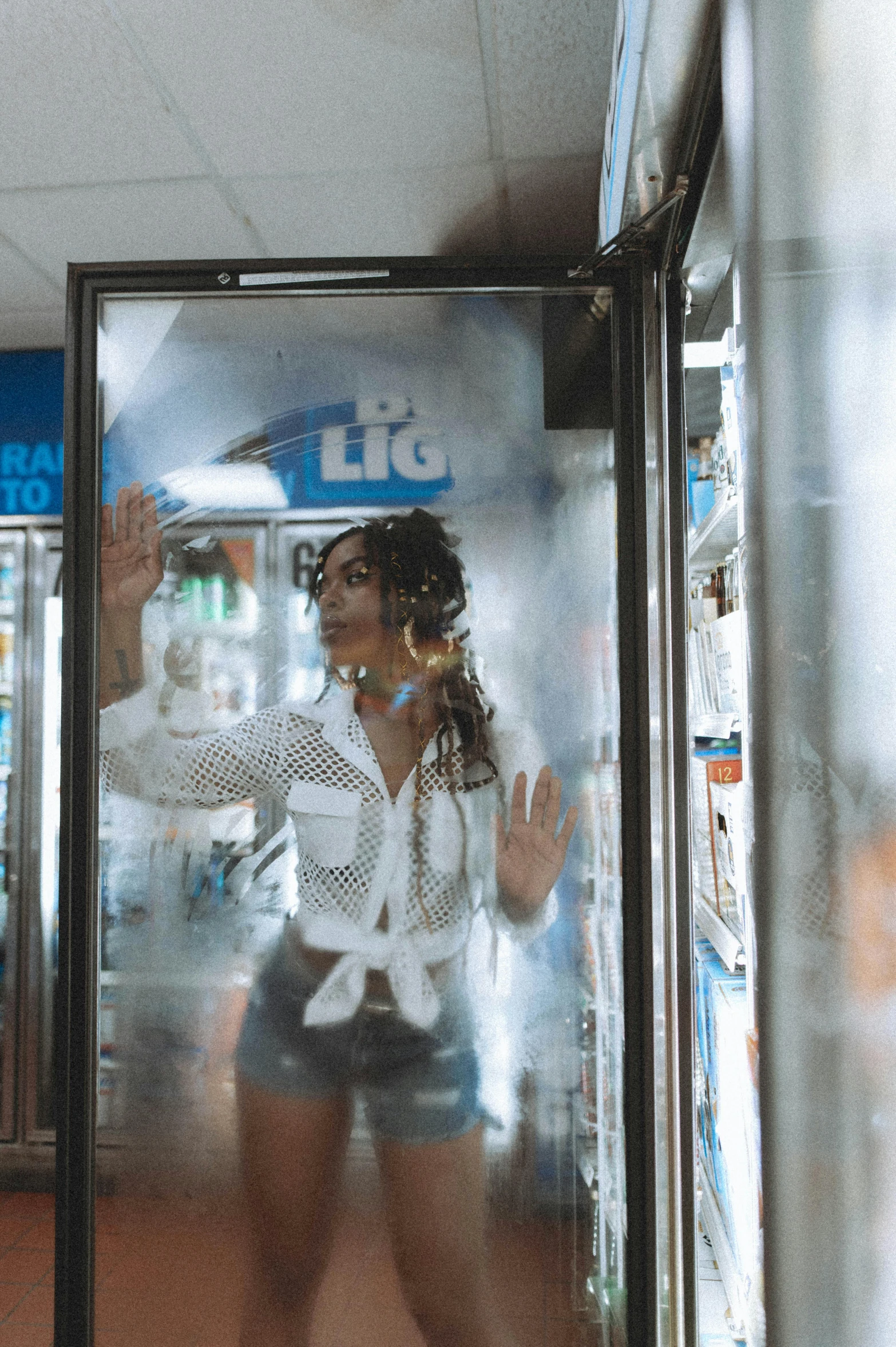 a woman standing in front of a phone booth, an album cover, by Daniel Lieske, pexels contest winner, fridge, see through, inside a gas station, female made of ice