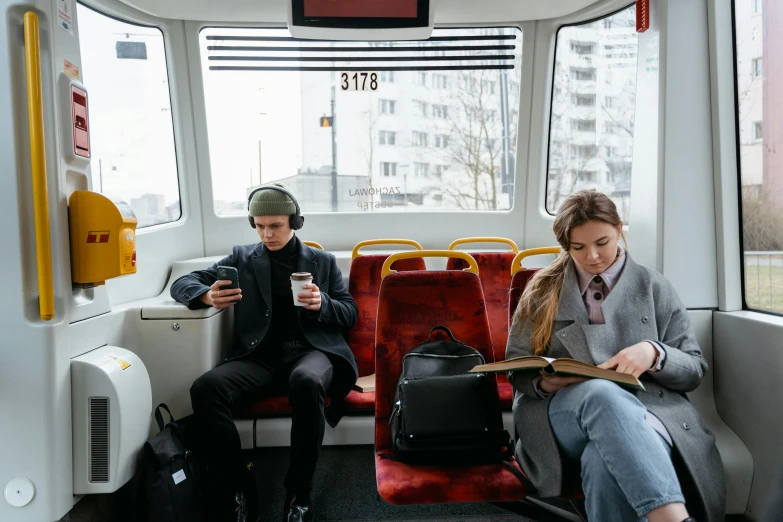 a couple of people sitting next to each other on a bus, by Emma Andijewska, trending on unsplash, carriage full of computers, worksafe. instagram photo, edmund blair and charlie bowater, coffee