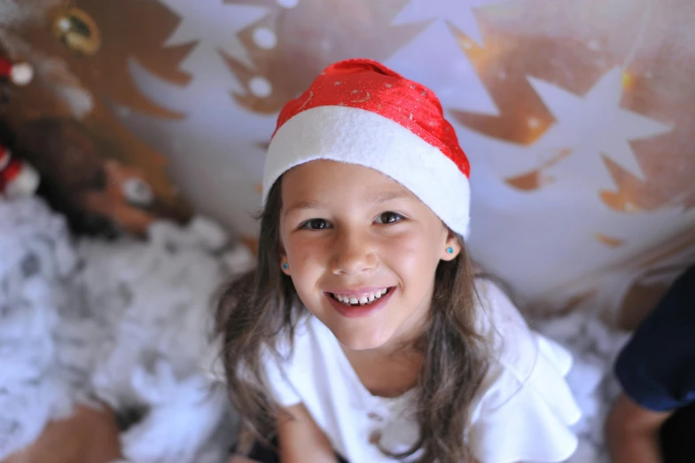 a little girl wearing a santa hat on top of a bed, pexels, graffiti, avatar image, smiling down from above, santa's workshop, 15081959 21121991 01012000 4k