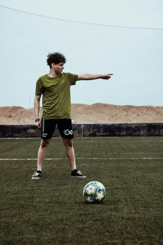 a man standing next to a soccer ball on a field, shooting pose, 15081959 21121991 01012000 4k, declan mckenna, action sports