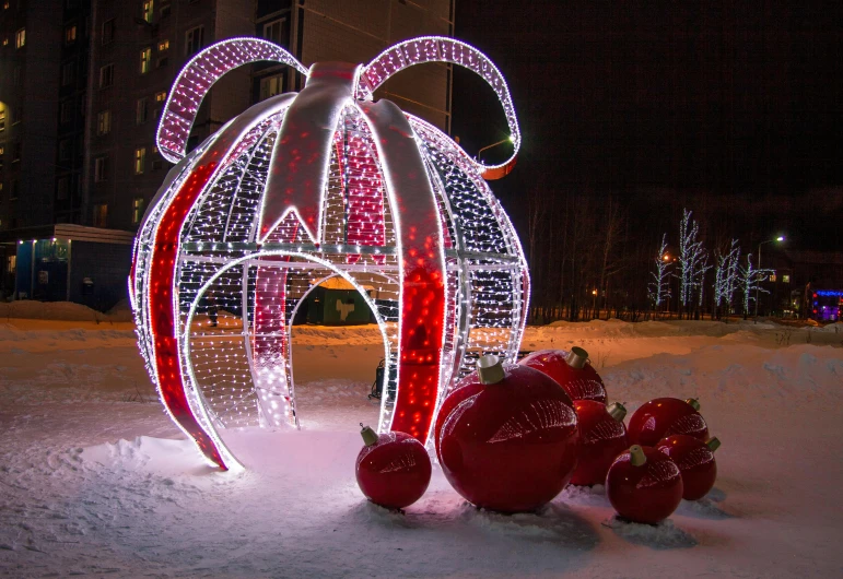 a red and white christmas decoration in the snow, by Maksimilijan Vanka, pexels contest winner, electricity archs, ornamental bow, espoo, uplit