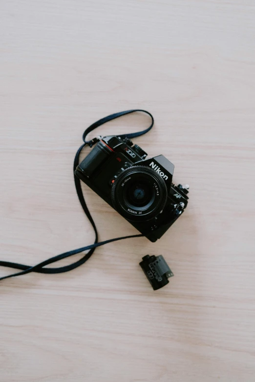 a camera sitting on top of a wooden table, by Niko Henrichon, minimalism, on a white table, unsplash 4k, a high angle shot, crawling towards the camera