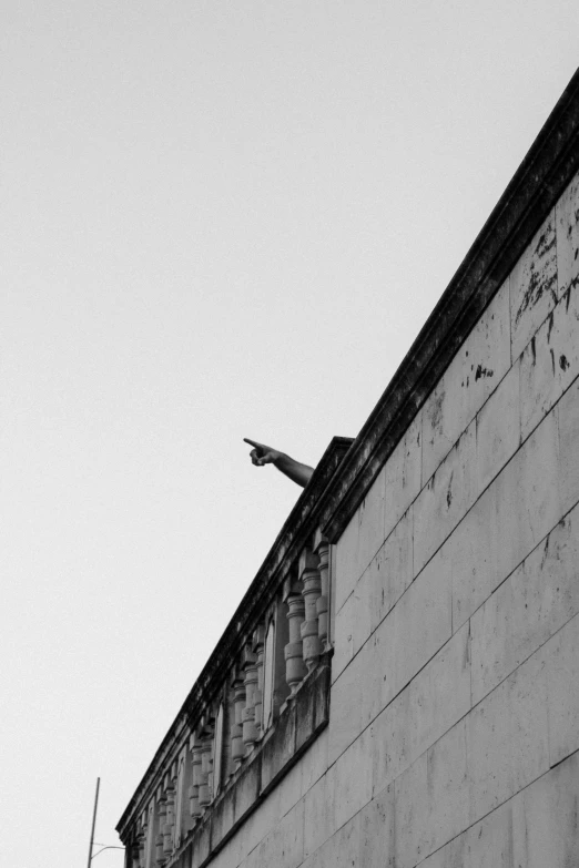 a man flying through the air while riding a skateboard, a black and white photo, unsplash, postminimalism, building crumbling, giving the middle finger, surveillance, wing