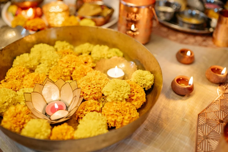 a close up of a bowl of food on a table, hurufiyya, lamps and flowers, golden glistening, medium level shot, marigold celestial vibe