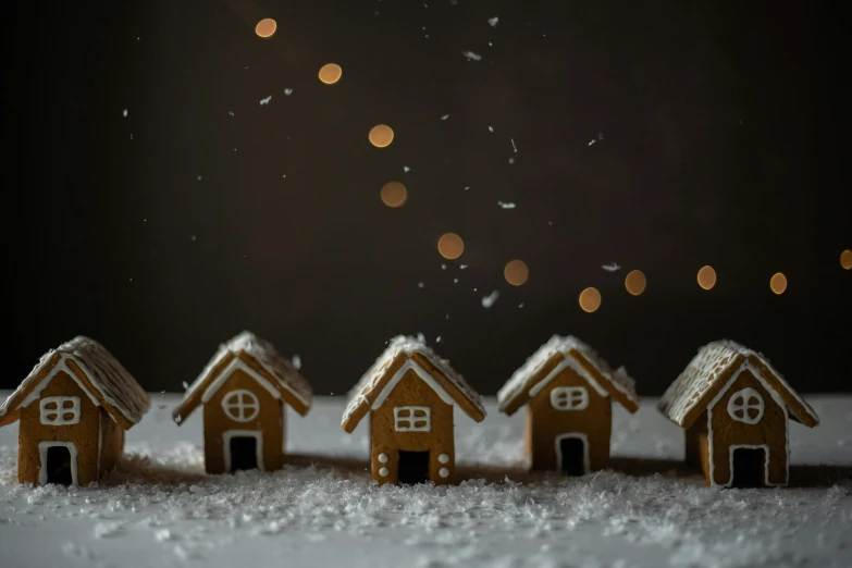 a group of ginger houses sitting on top of a snow covered ground, pexels contest winner, realism, on a dark background, gif, tiny house, holiday