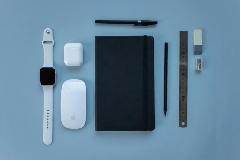 an apple watch, notepad, pen, and other items laid out on a blue surface, a still life, inspired by Robert Mapplethorpe, unsplash, minimalism, white mouse technomage, monochrome 3 d model, holding notebook, high-tech devices
