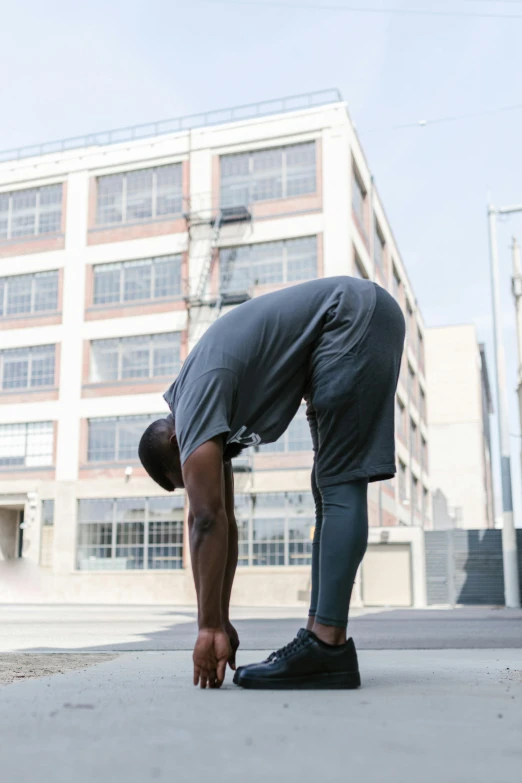 a man doing a handstand on a skateboard, happening, wearing adidas clothing, praying posture, black man, promo image