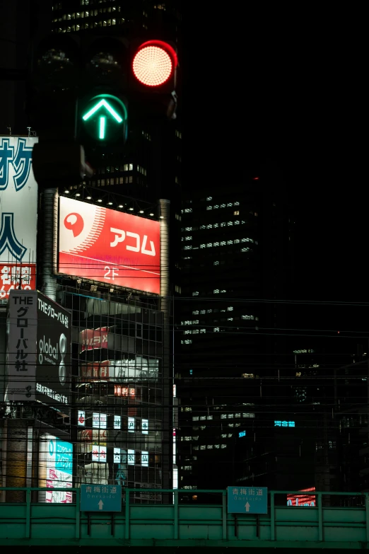 a traffic light on a city street at night, a poster, inspired by Kanō Naizen, neoism, electronic ads, skyline showing, in tokio, ap