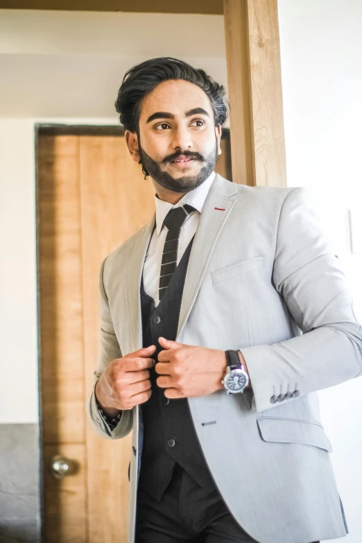 a man in a suit adjusting his tie, inspired by Manjit Bawa, trending on pexels, full body with costume, grey skin, androgynous person, curled beard